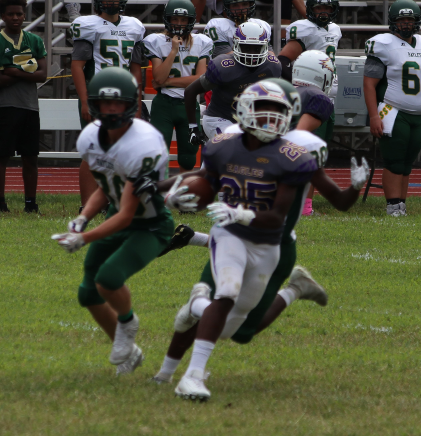 Xavier Lane (junior) rushes with the ball, fighting hard for the win