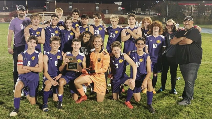 The soccer team poses together after winning the title of district champions.