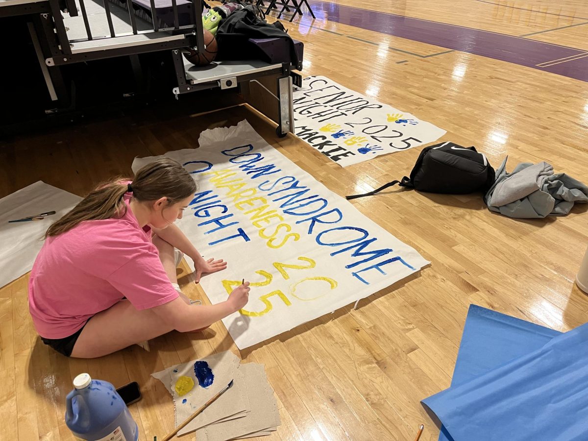 Juniors Kelsea Hansard and Kensington Curd paint signs in anticipation for Katie Mackie's senior night. 