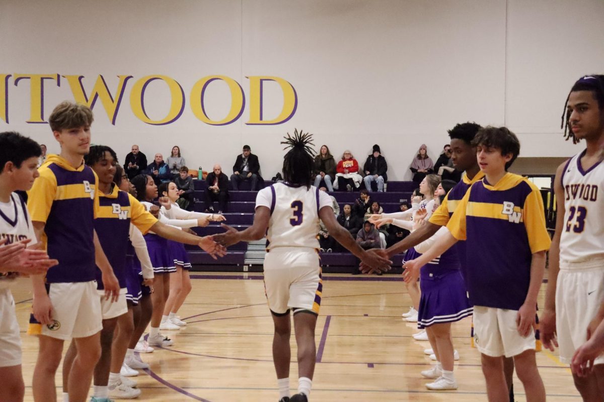 Tyler Taylor (12)  runs out to the court with the support of his team.