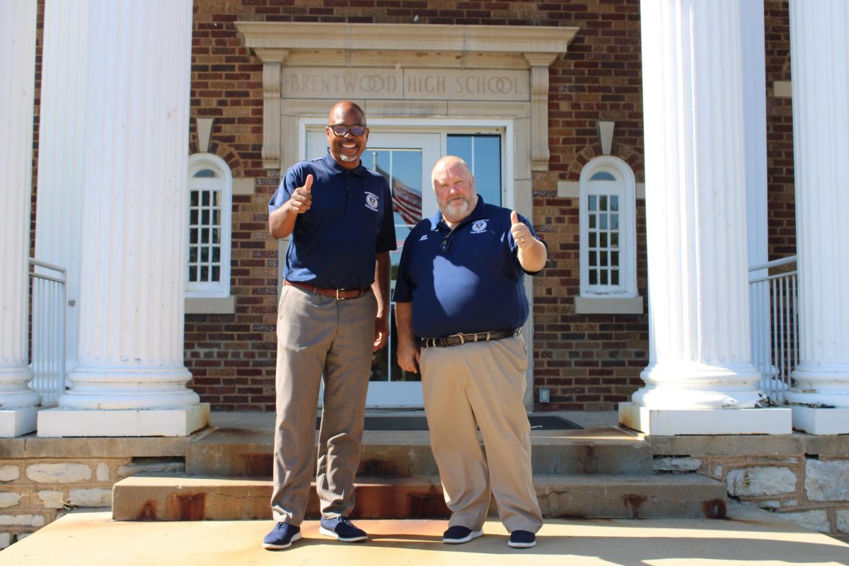 Dr. Johnson and Dr. Ayotte pose in front of the school. 